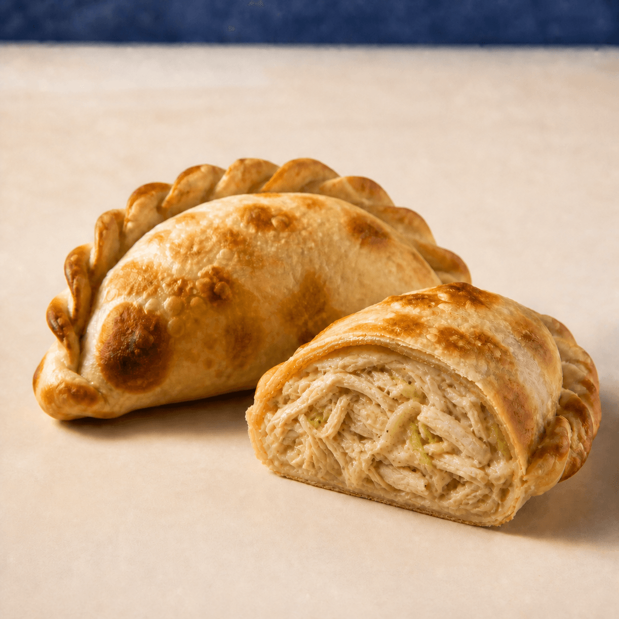 Pollo y puerro DOBLEZ, empanada horneada abierta mostrando su relleno